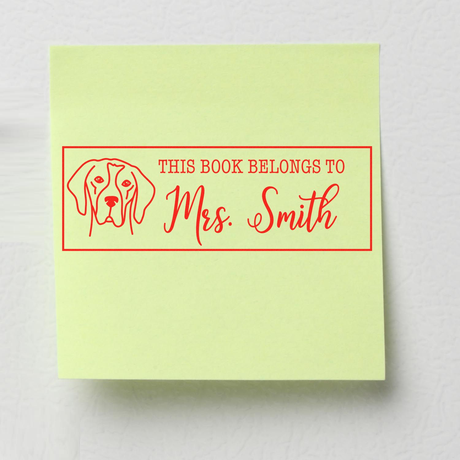 Personalized rubber book stamp with dog illustration reading This Book Belongs to Mrs. Smith for library or classroom use.
