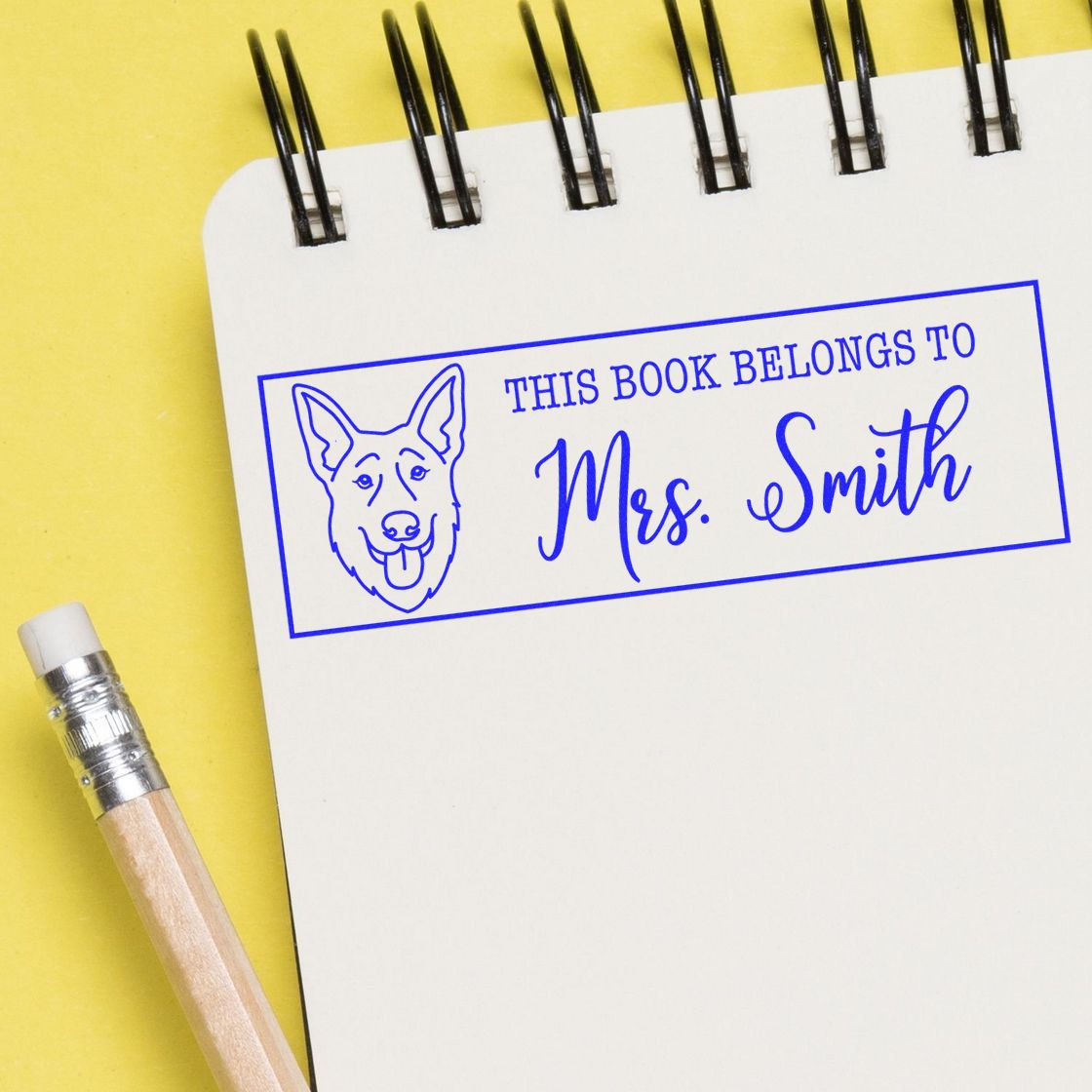 Personalized rubber book stamp with dog design reading This Book Belongs to Mrs. Smith.