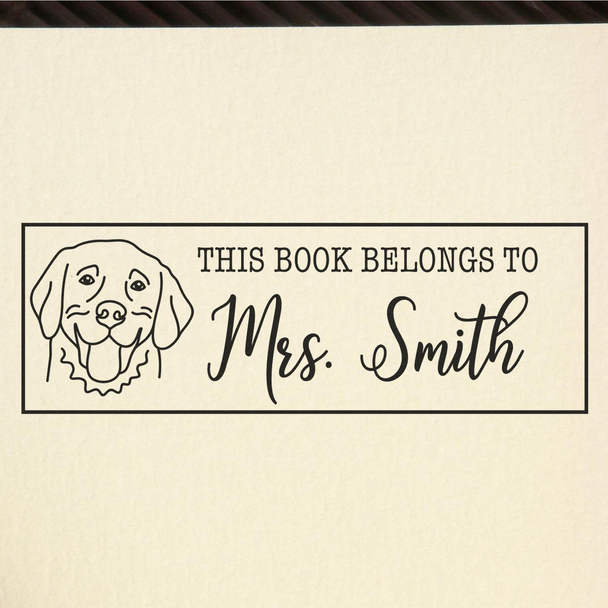 Personalized rubber book stamp with dog illustration and This book belongs to Mrs. Smith text for custom library books.