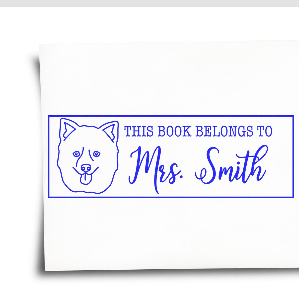 Personalized rubber book stamp with dog illustration and This Book Belongs to Mrs. Smith text for custom library labels.