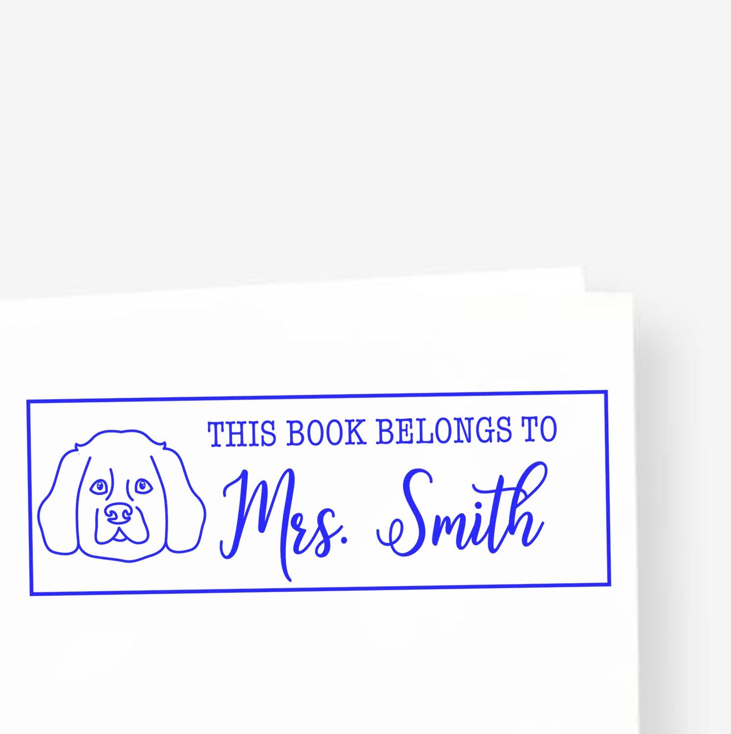 Custom rubber stamp for books, featuring a dog illustration and This Book Belongs to Mrs. Smith for personalized ownership.