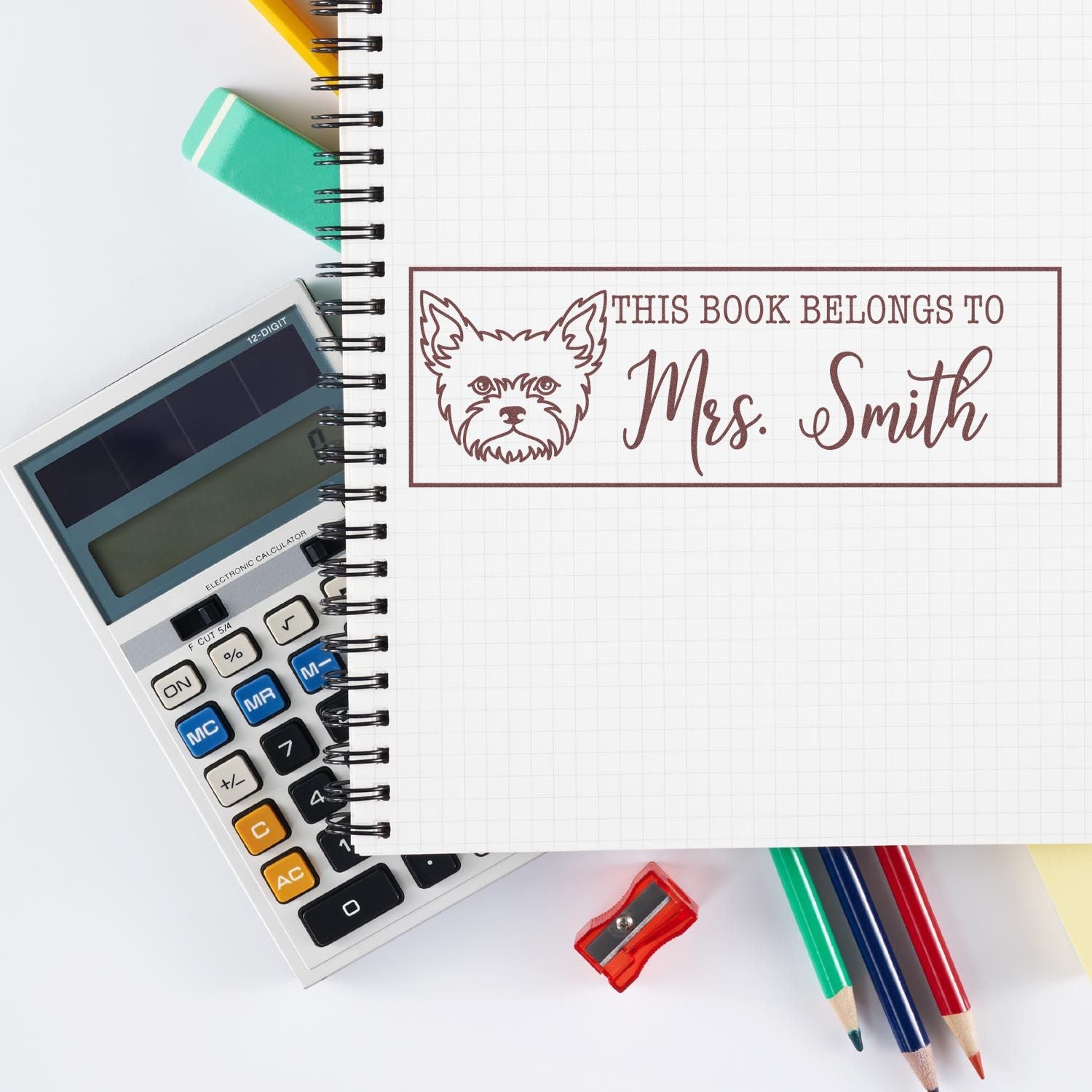 Personalized rubber stamp design with dog illustration and This Book Belongs to Mrs. Smith text for custom book labeling.