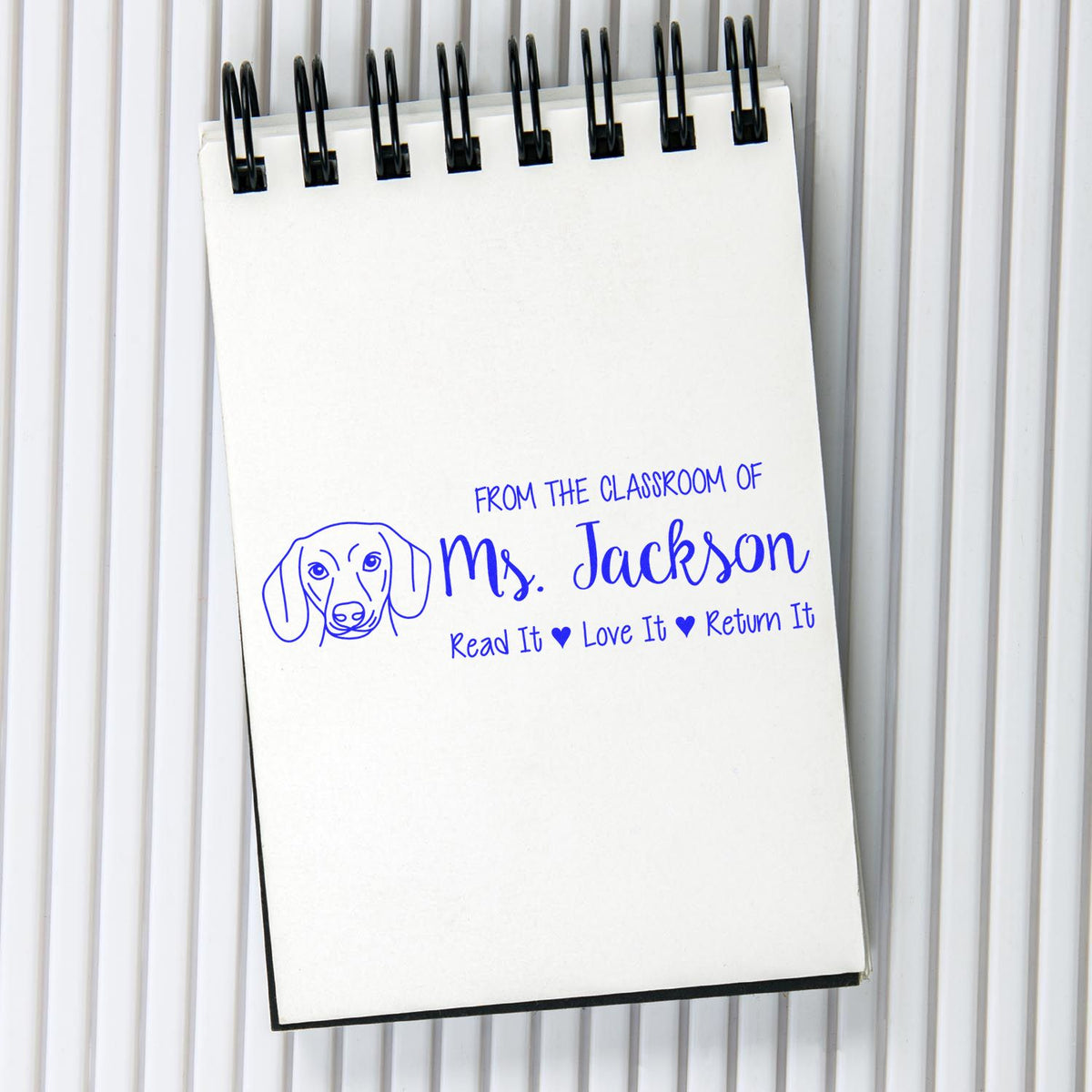 Custom classroom rubber stamp with dog logo and From the Classroom of Ms. Jackson, Read It, Love It, Return It text.