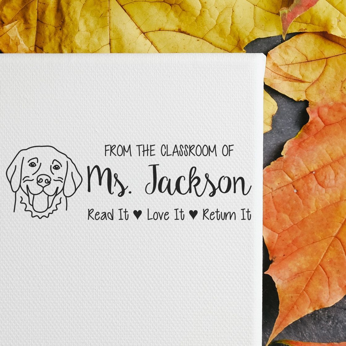 Personalized teacher rubber stamp for Ms. Jacksons classroom books: Read It, Love It, Return It with dog logo.