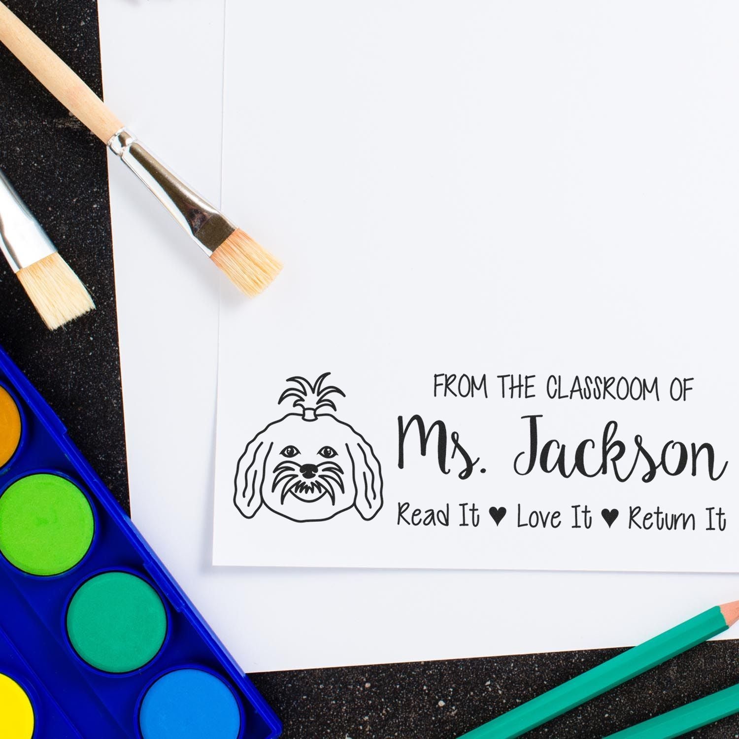 Teacher classroom rubber stamp reading From the classroom of Ms. Jackson, Read It Love It Return It with dog logo