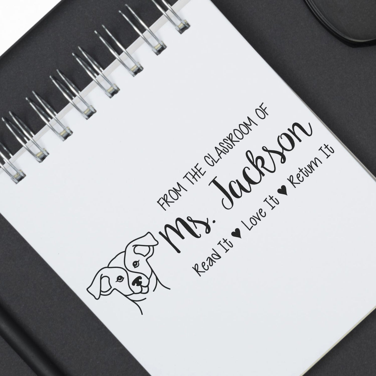 Custom teacher rubber stamp with dog illustration, featuring From the classroom of Mrs. Jackson book return message.