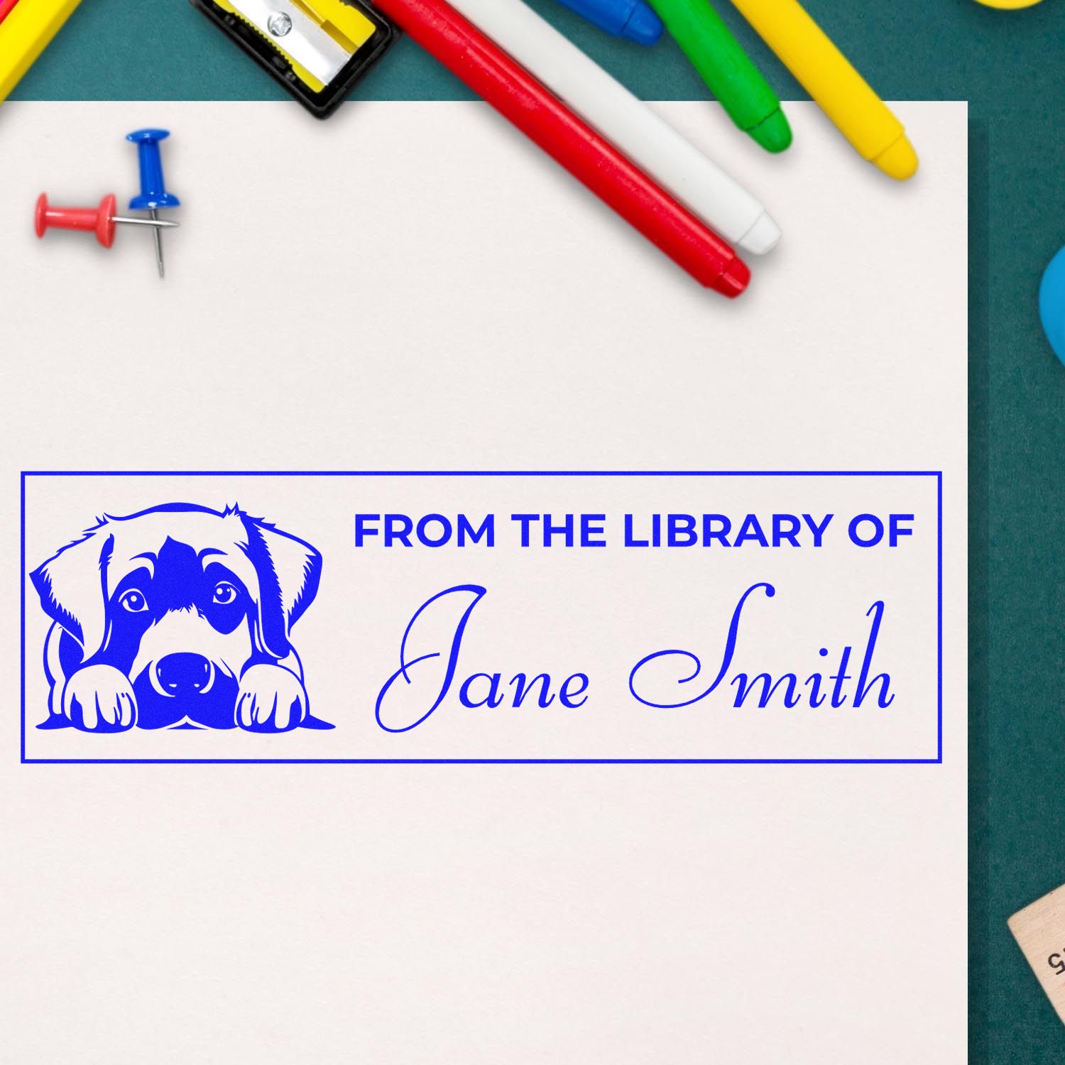 Personalized dog-themed library rubber stamp reading From the Library of Jane Smith for books, classrooms, and stationery.