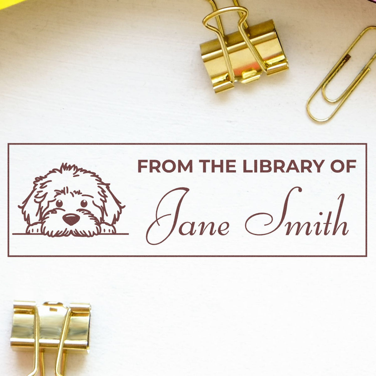 Personalized library rubber stamp with dog art, designed to mark books and stationery with a custom name.