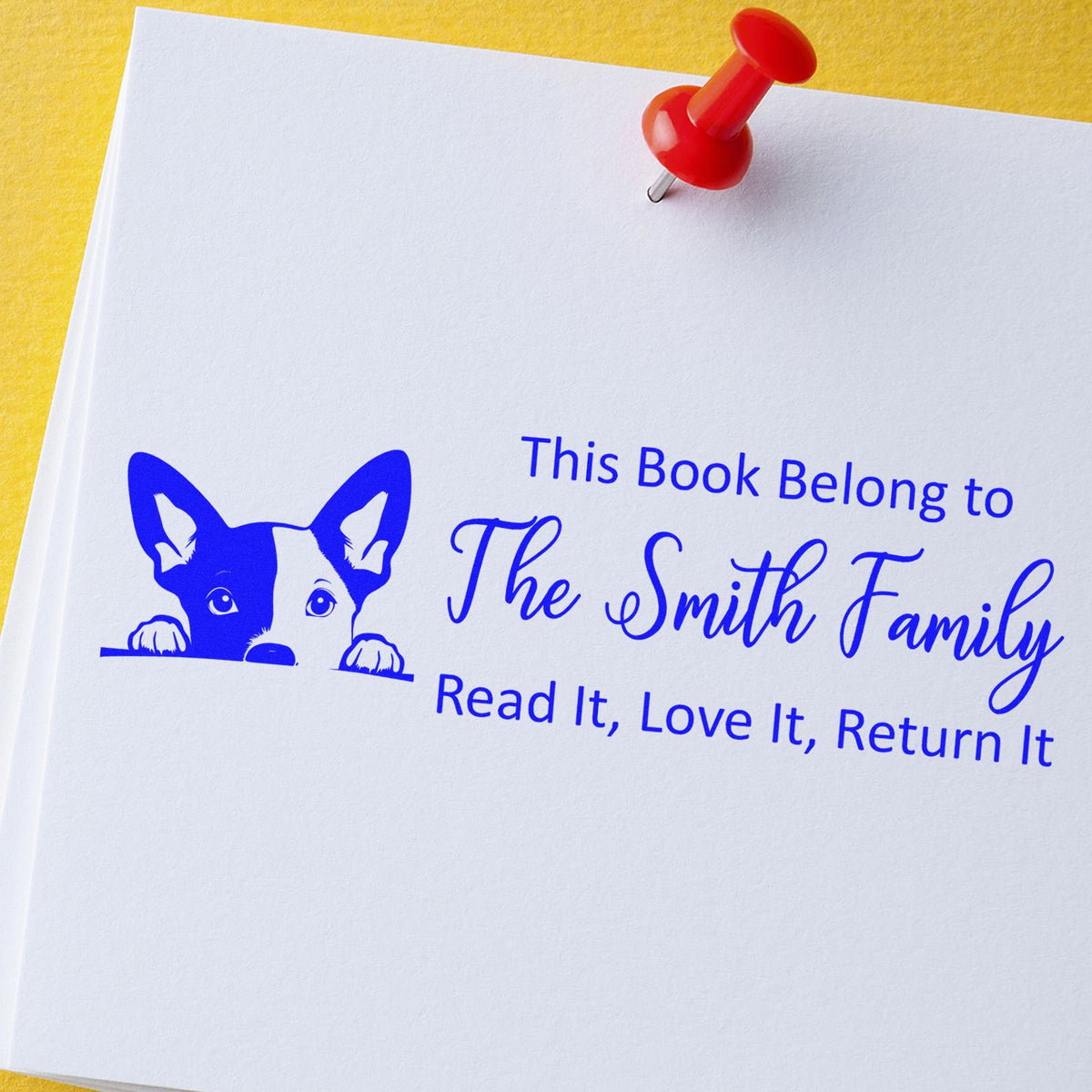 Personalized rubber stamp for books with dog design and red pushpin: This Book Belong to The Smith Family, Read It, Love It, Return It.