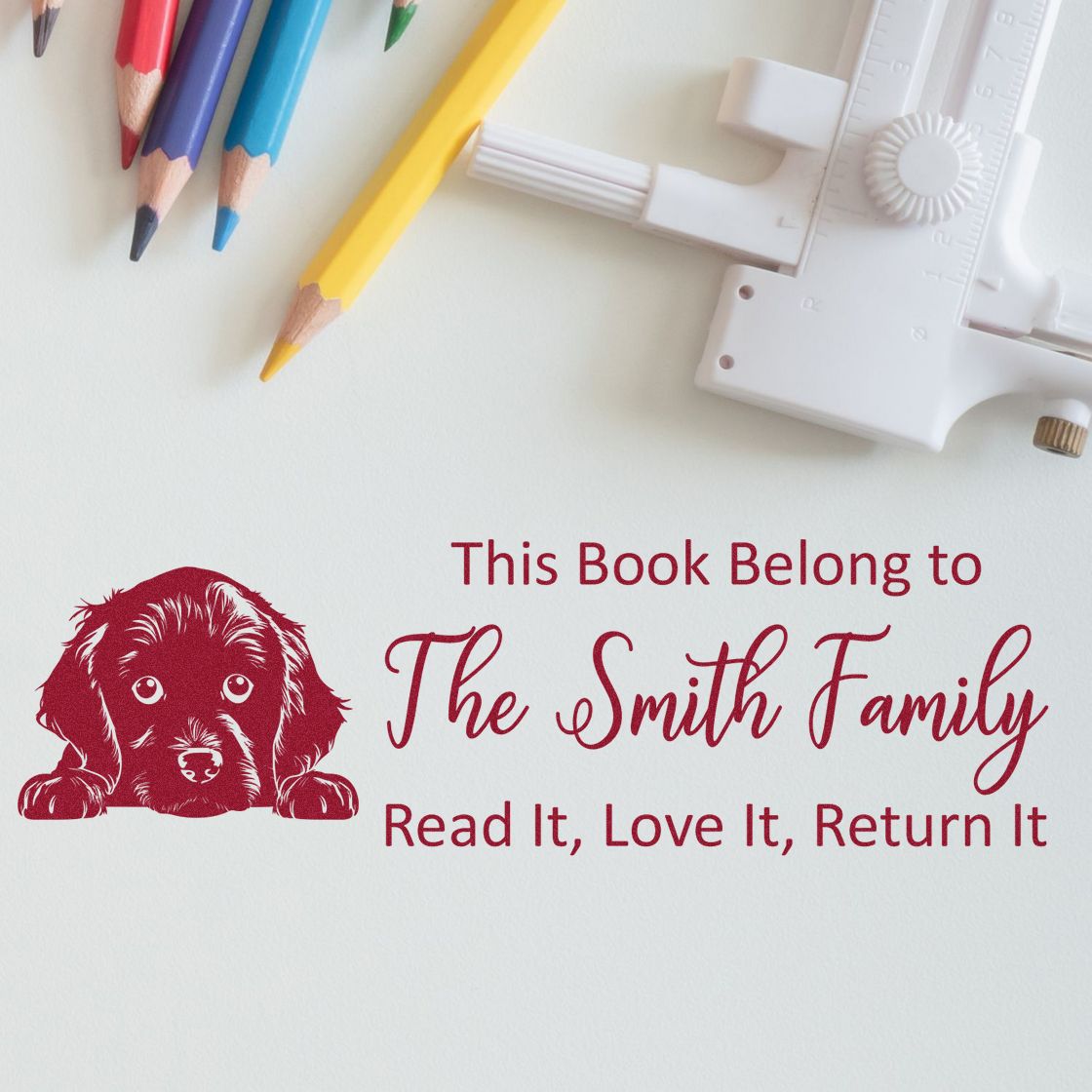 Custom rubber stamp bookplate with dog illustration and This Book Belongs to The Smith Family for library books.