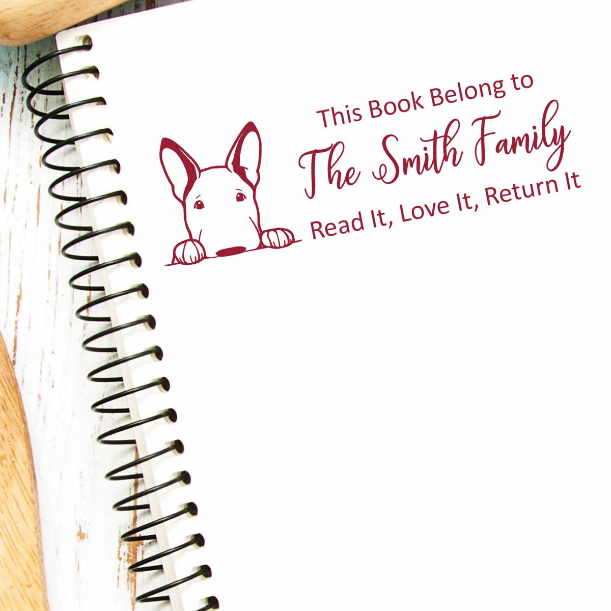 Custom rubber stamp for books with dog illustration and This Book Belongs to The Smith Family return-to-owner message.