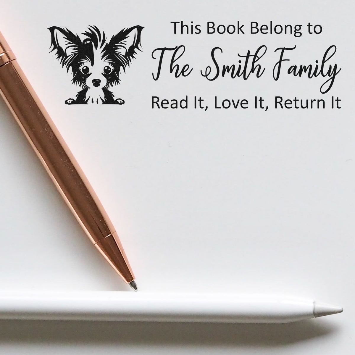Personalized book rubber stamp with dog graphic and This Book Belongs to The Smith Family, Read It Love It Return It message.