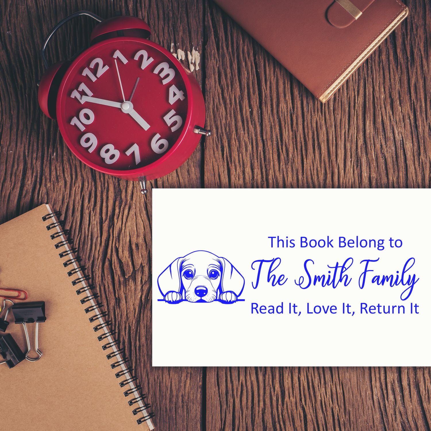 Custom book rubber stamp design with dog illustration and family name for library books.