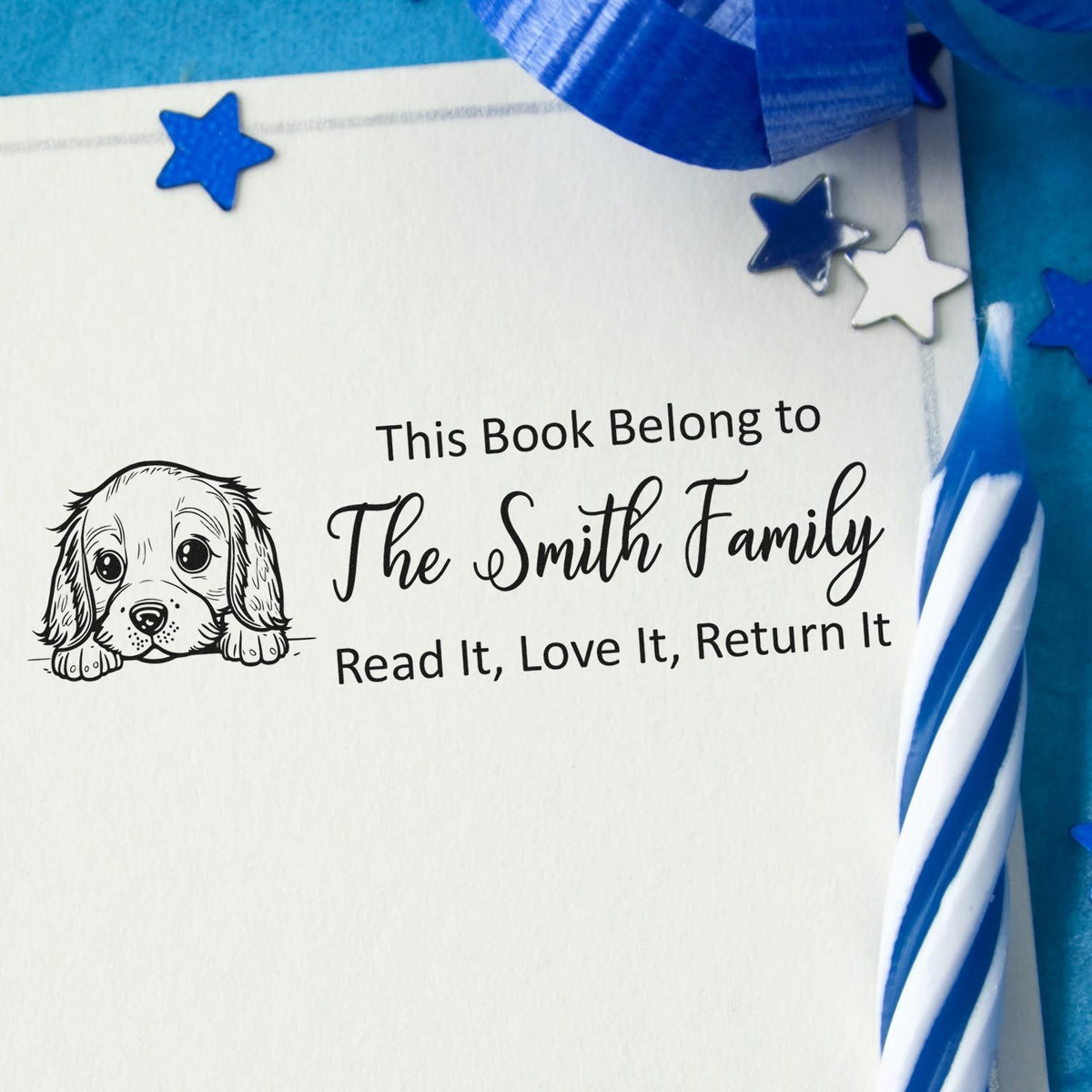 Personalized rubber book stamp with puppy design and This Book Belongs to The Smith Family return label for library books.