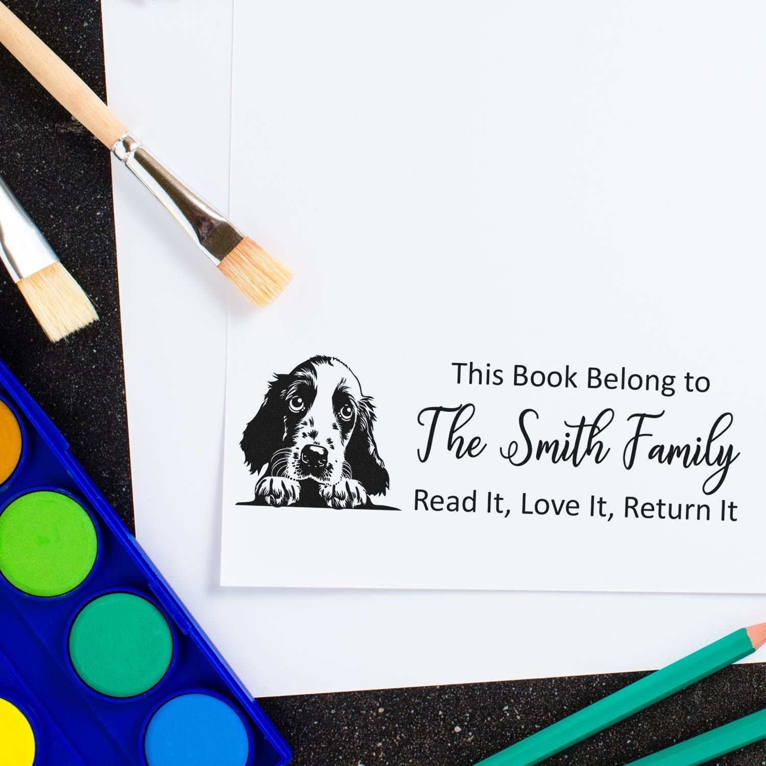 Custom book rubber stamp with dog illustration and personalized "This Book Belongs to The Smith Family" return message.