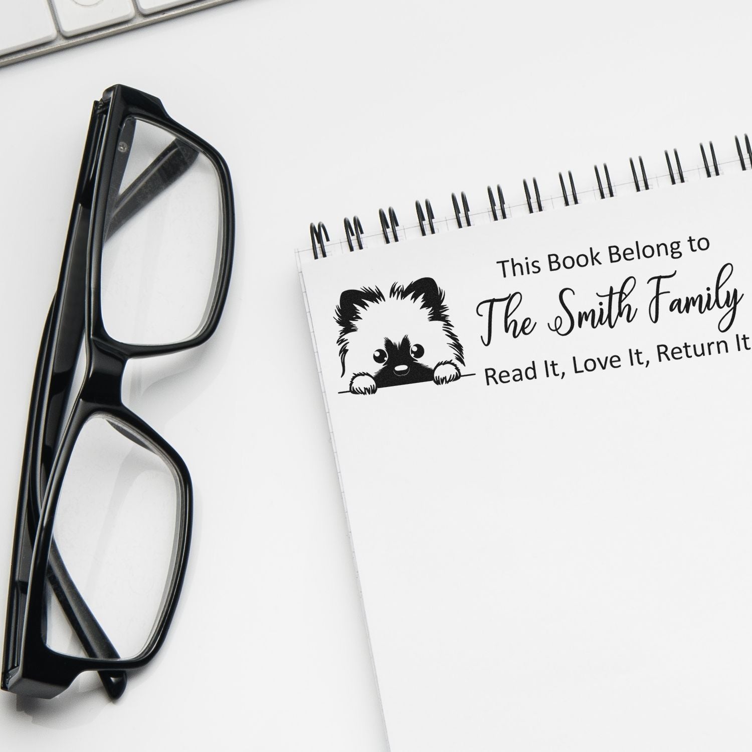 Custom book belongs rubber stamp with dog design and family name for personalizing children's books.