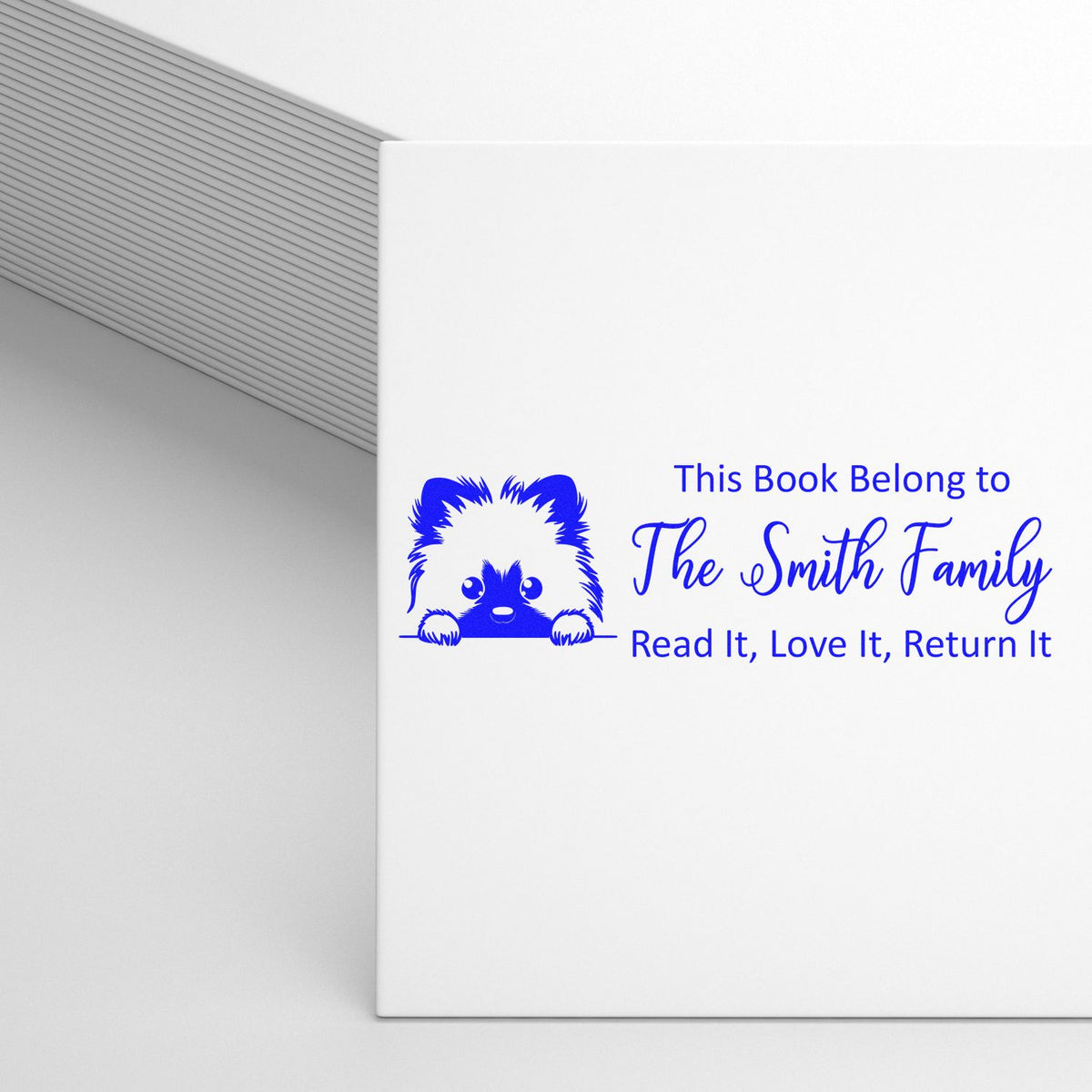 Personalized rubber book stamp with dog graphic and This Book Belongs to The Smith Family read-it, love-it, return-it message.