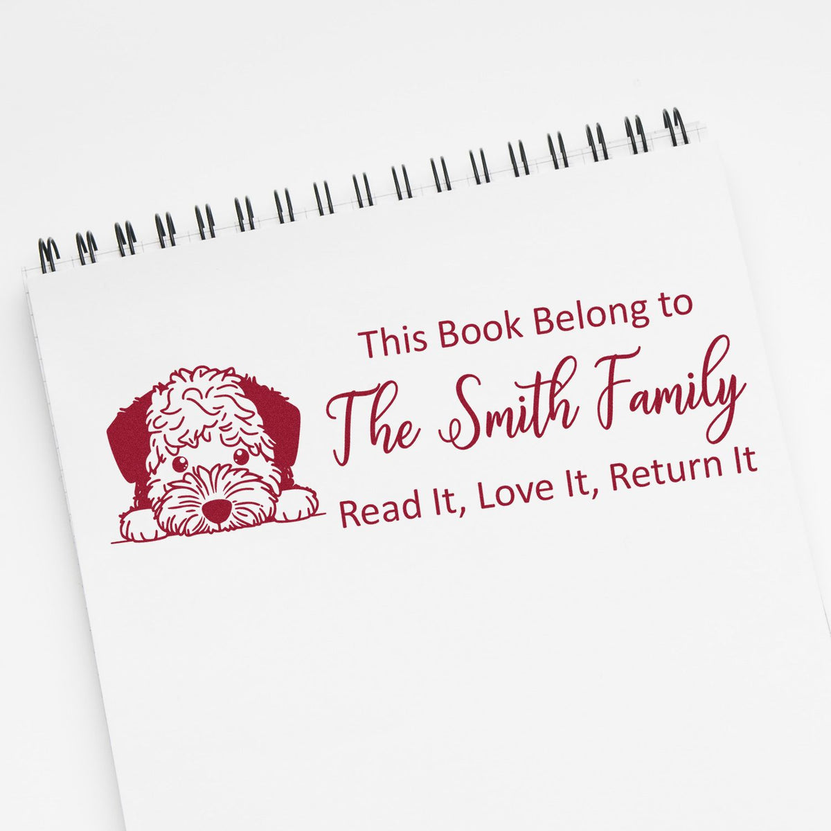 Personalized rubber stamp for books with dog design and This Book Belongs to The Smith Family return message.