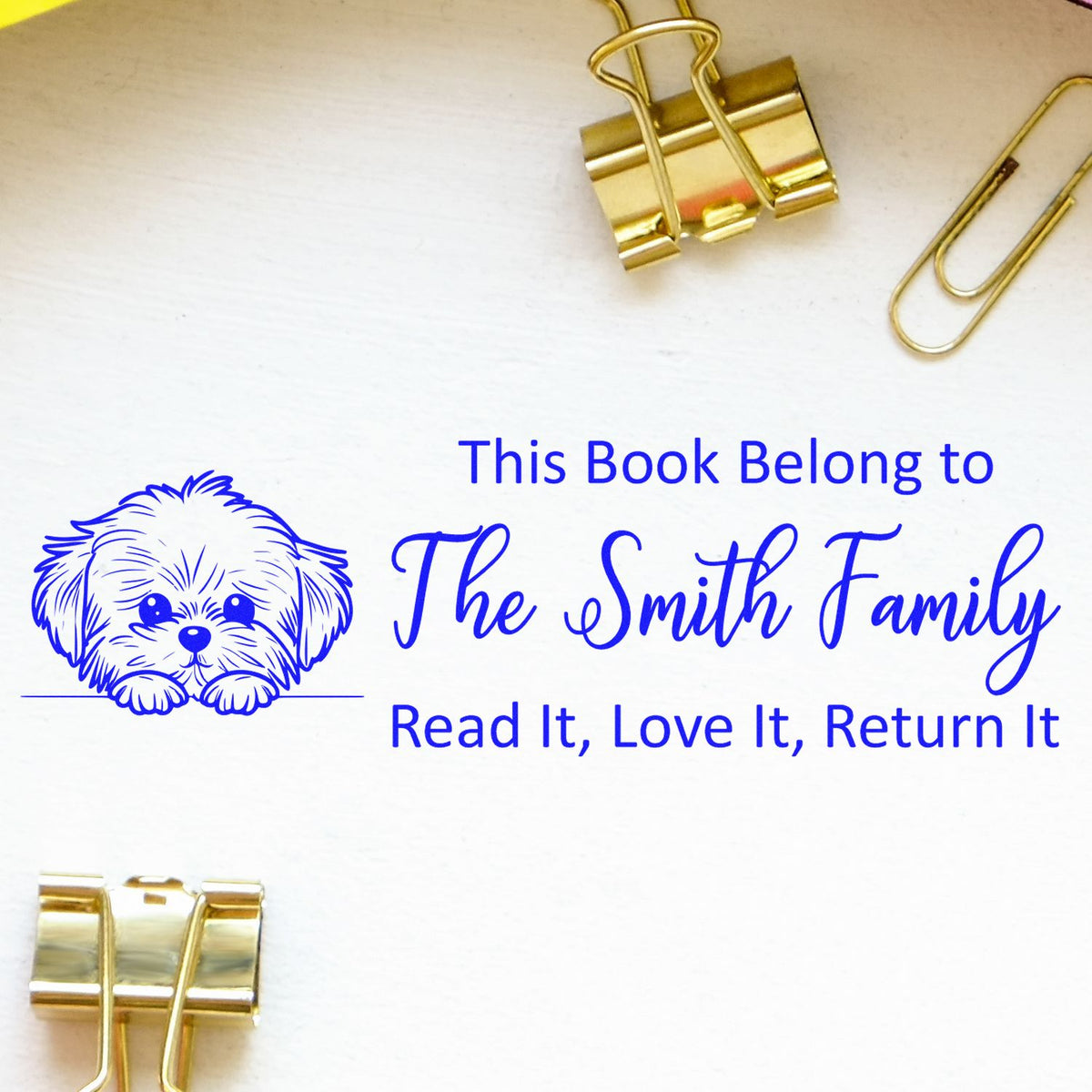 Custom rubber book stamp with dog design, personalized for The Smith Family, reading This book belongs to The Smith Family.