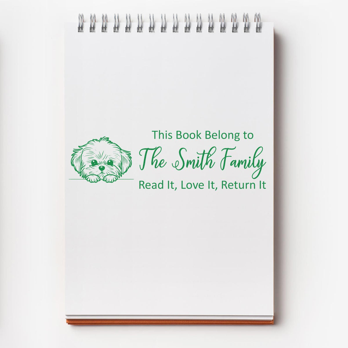 Personalized rubber stamp bookplate with dog illustration and This Book Belong to The Smith Family read-and-return message.