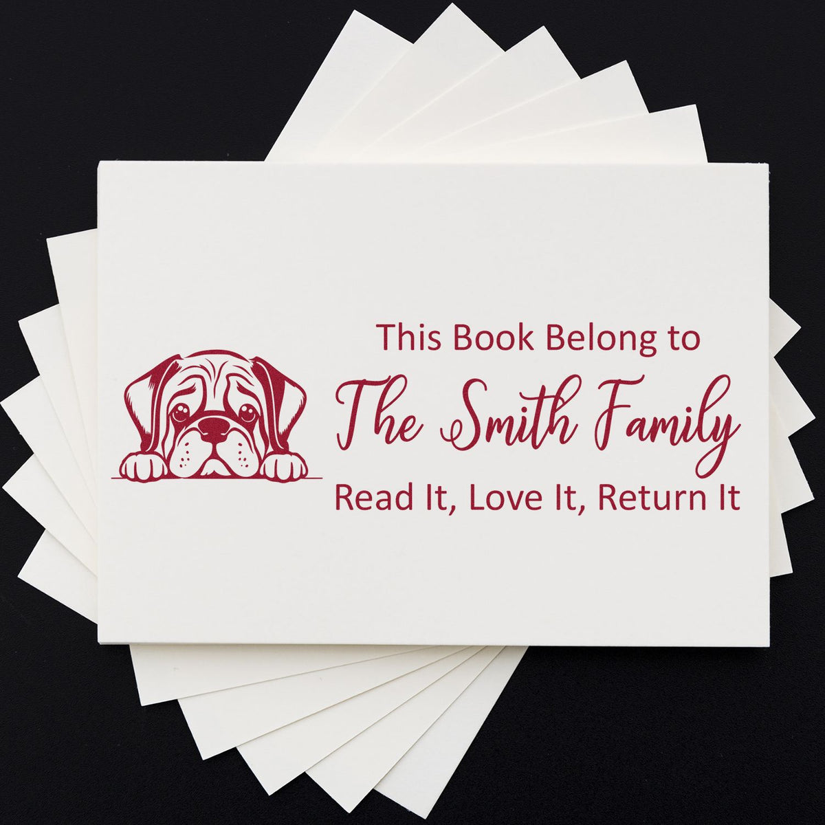 Custom rubber book return stamp with dog design and family name, perfect for personalized library labels and borrowed books.
