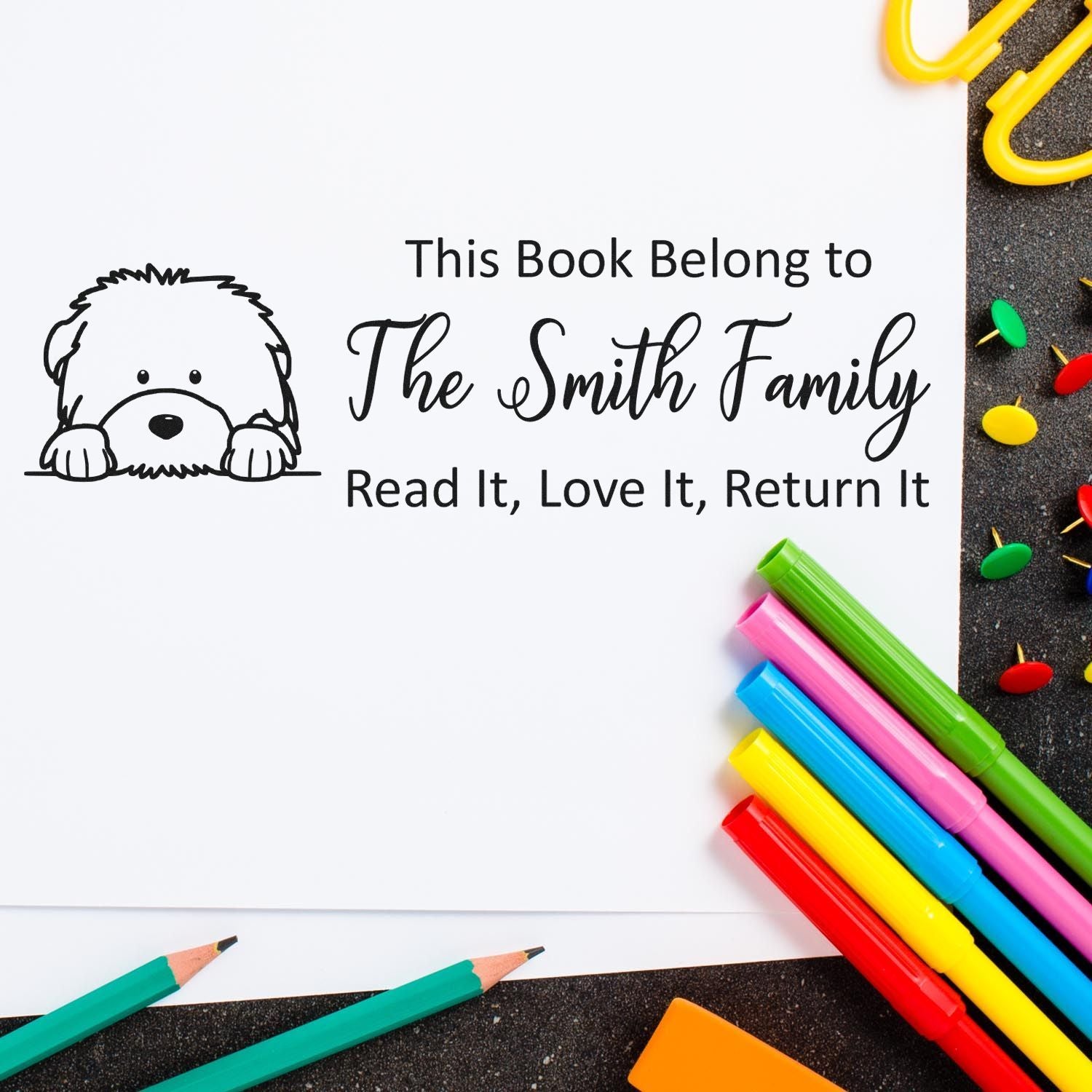 Personalized book stamp with dog design and This Book Belongs to The Smith Family text for labeling childrens books.