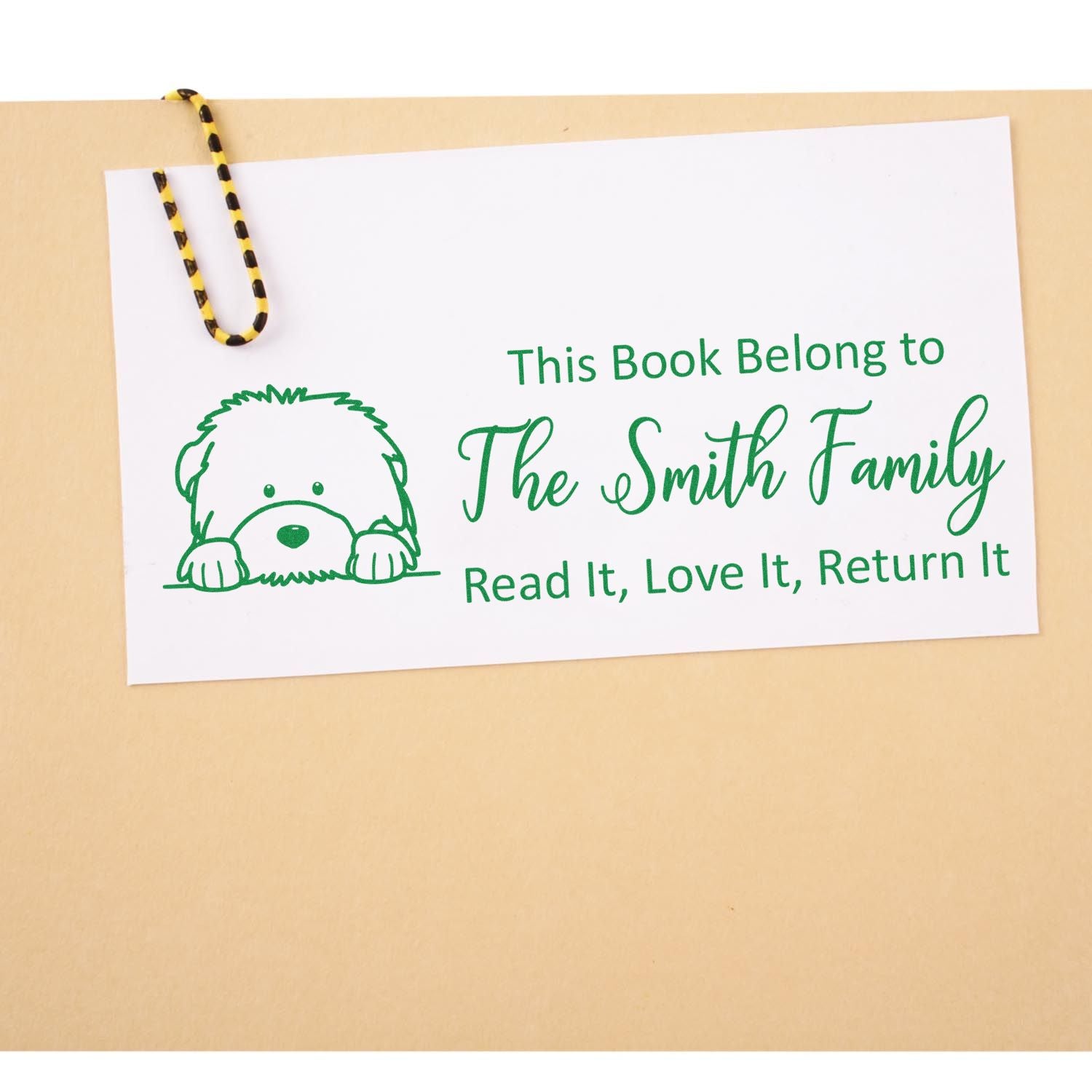 Custom rubber book stamp with dog illustration and This Book Belongs to The Smith Family return-and-reuse message.