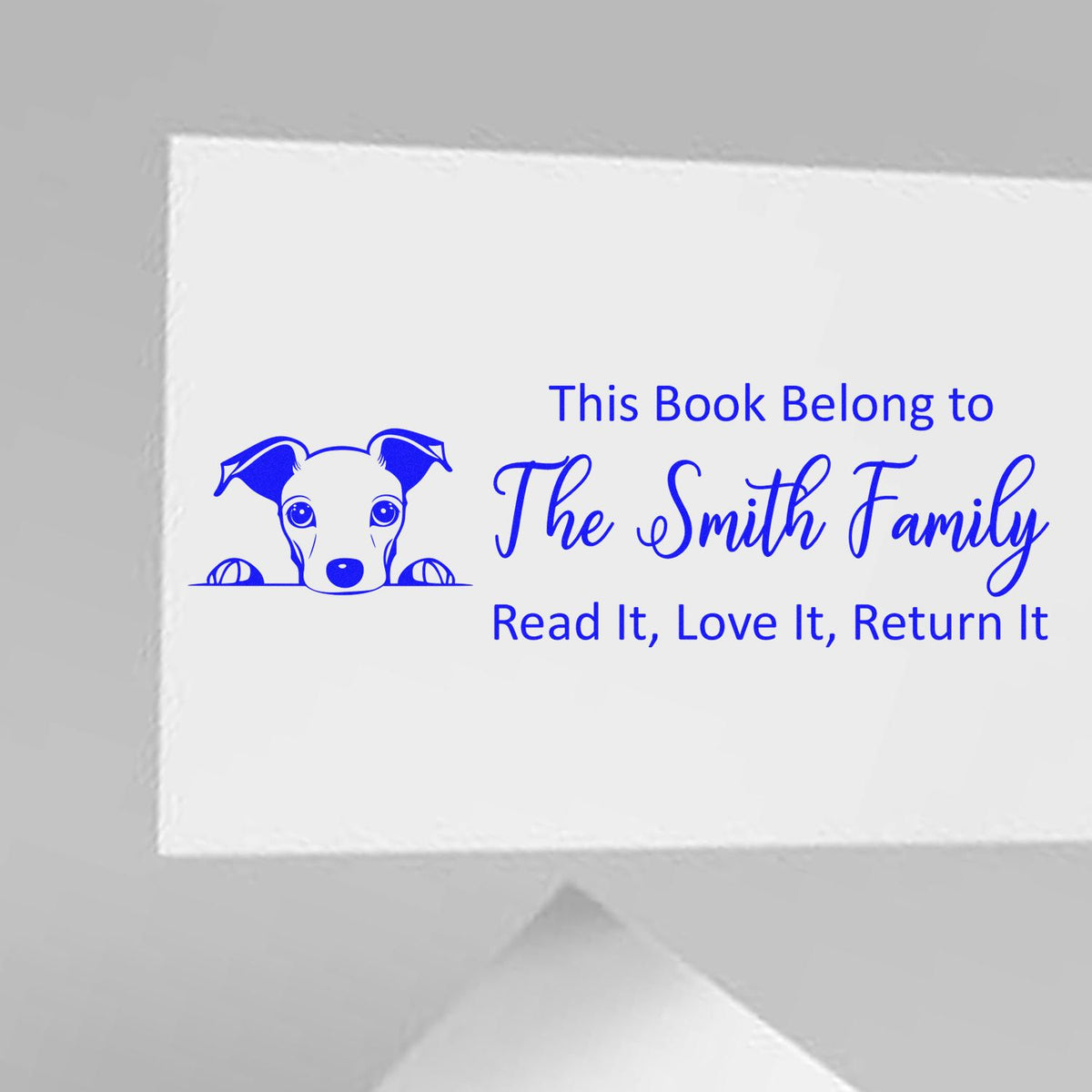 Personalized rubber book stamp with dog illustration and bookplate text: This Book Belongs to The Smith Family, Read It, Love It, Return It.