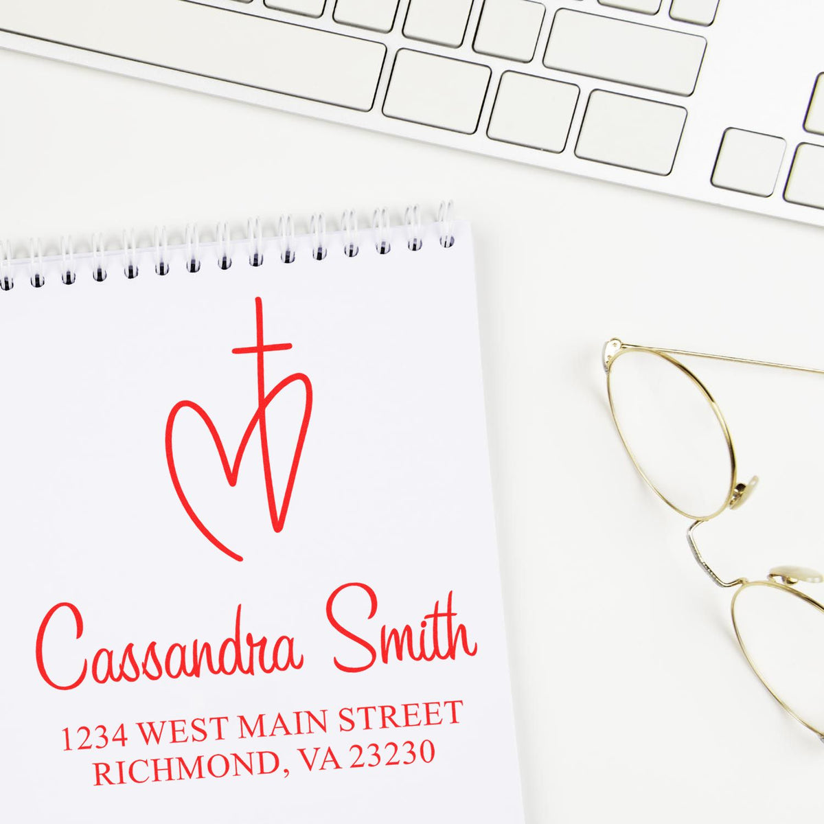 Custom return address rubber stamp impression with monogram, name, and address on notepad for personal mailing.