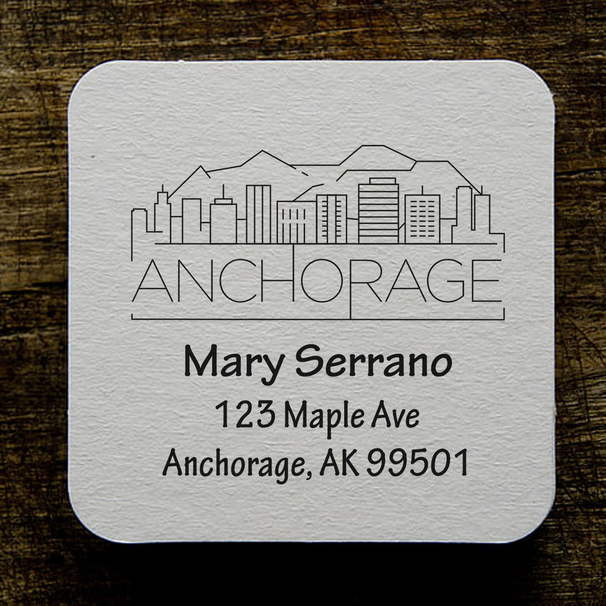 Custom Anchorage Alaska address rubber stamp with skyline design for Mary Serrano mailing label.