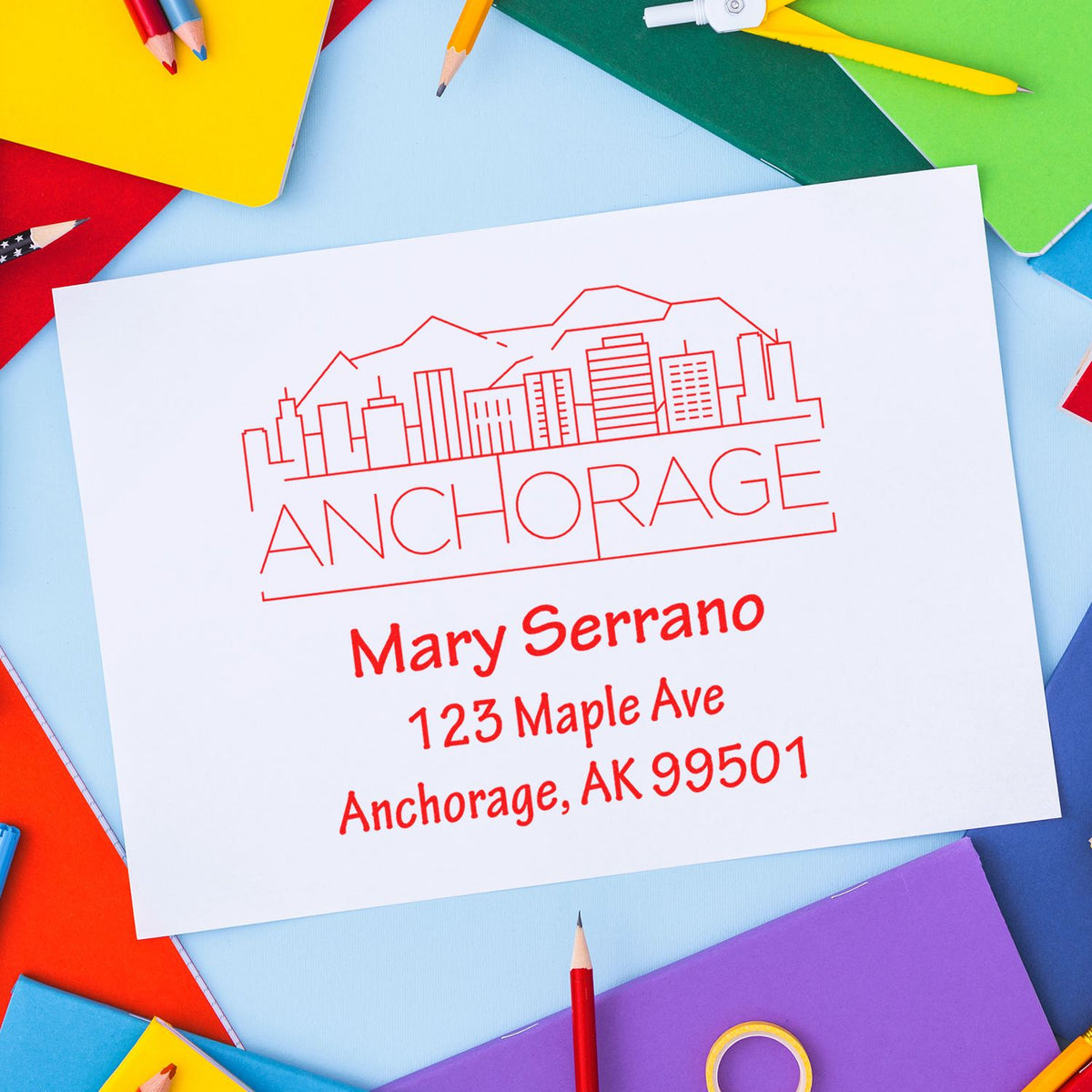 Custom Anchorage return address rubber stamp with skyline design and Mary Serrano mailing address.