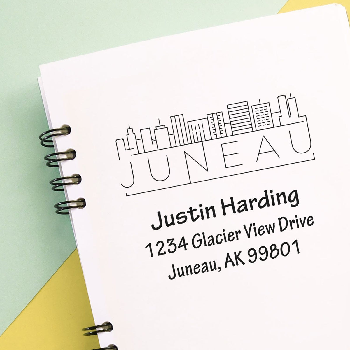 Custom Juneau return address rubber stamp with skyline logo, Justin Harding name, and Alaska mailing address for mailing and packaging.