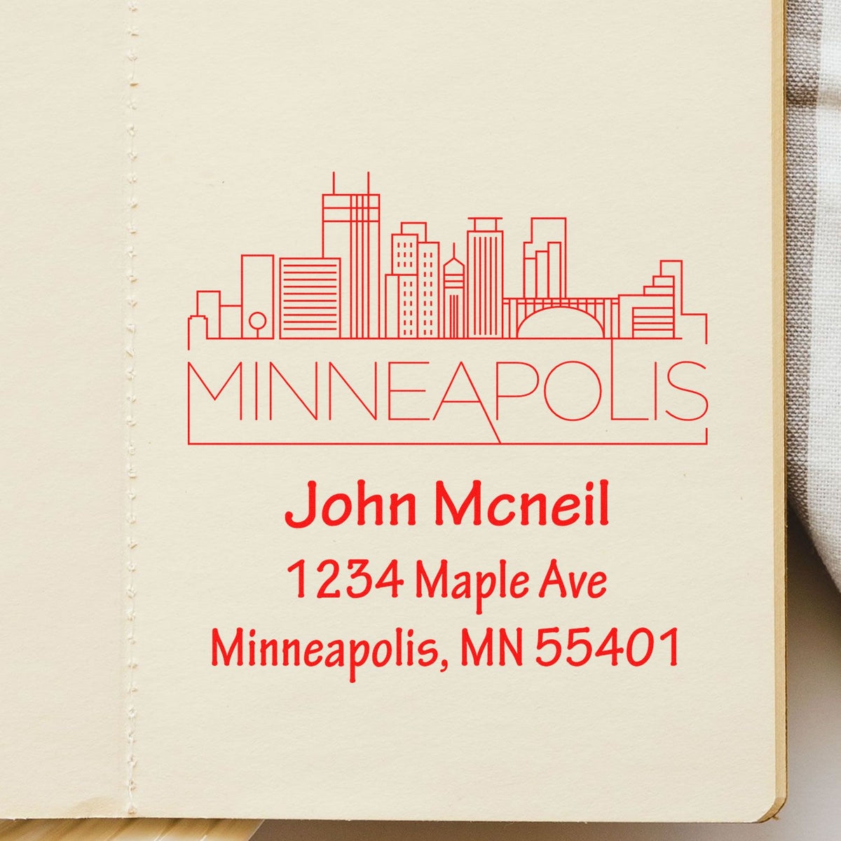 Personalized Minneapolis rubber stamp with skyline and return address for John McNeil, 1234 Maple Ave, Minneapolis, MN 55401.