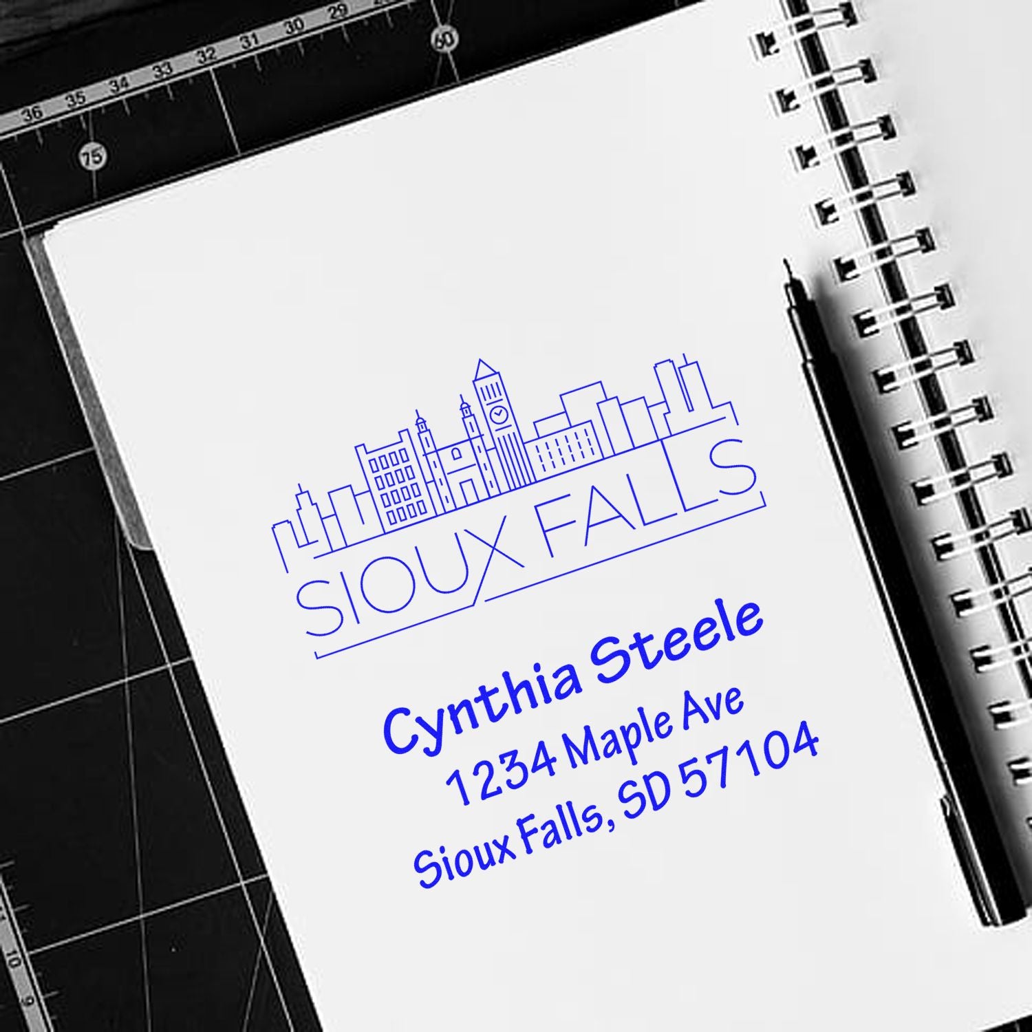 Custom Sioux Falls rubber address stamp with skyline logo, name, and mailing address for Cynthia Steele.