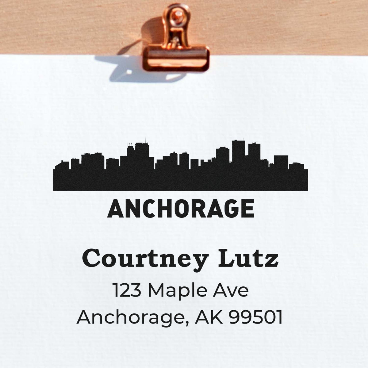 Custom Anchorage return address rubber stamp with skyline, Courtney Lutz name, and Anchorage, AK 99501 on paper.