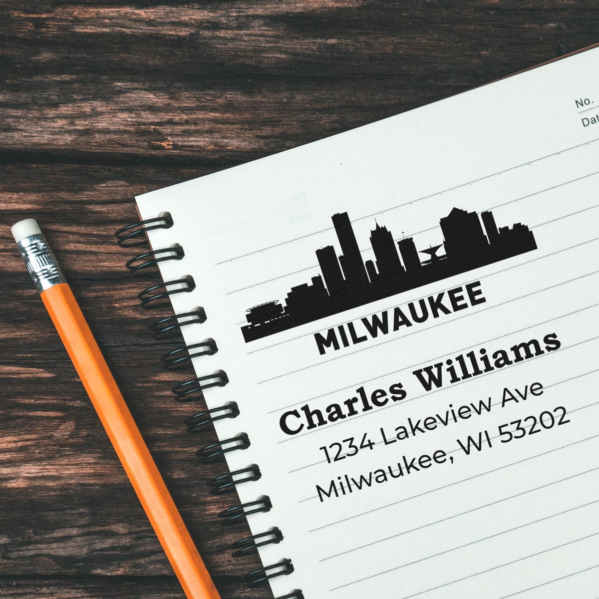 Personalized Milwaukee skyline rubber address stamp for Charles Williams with return address on notebook.