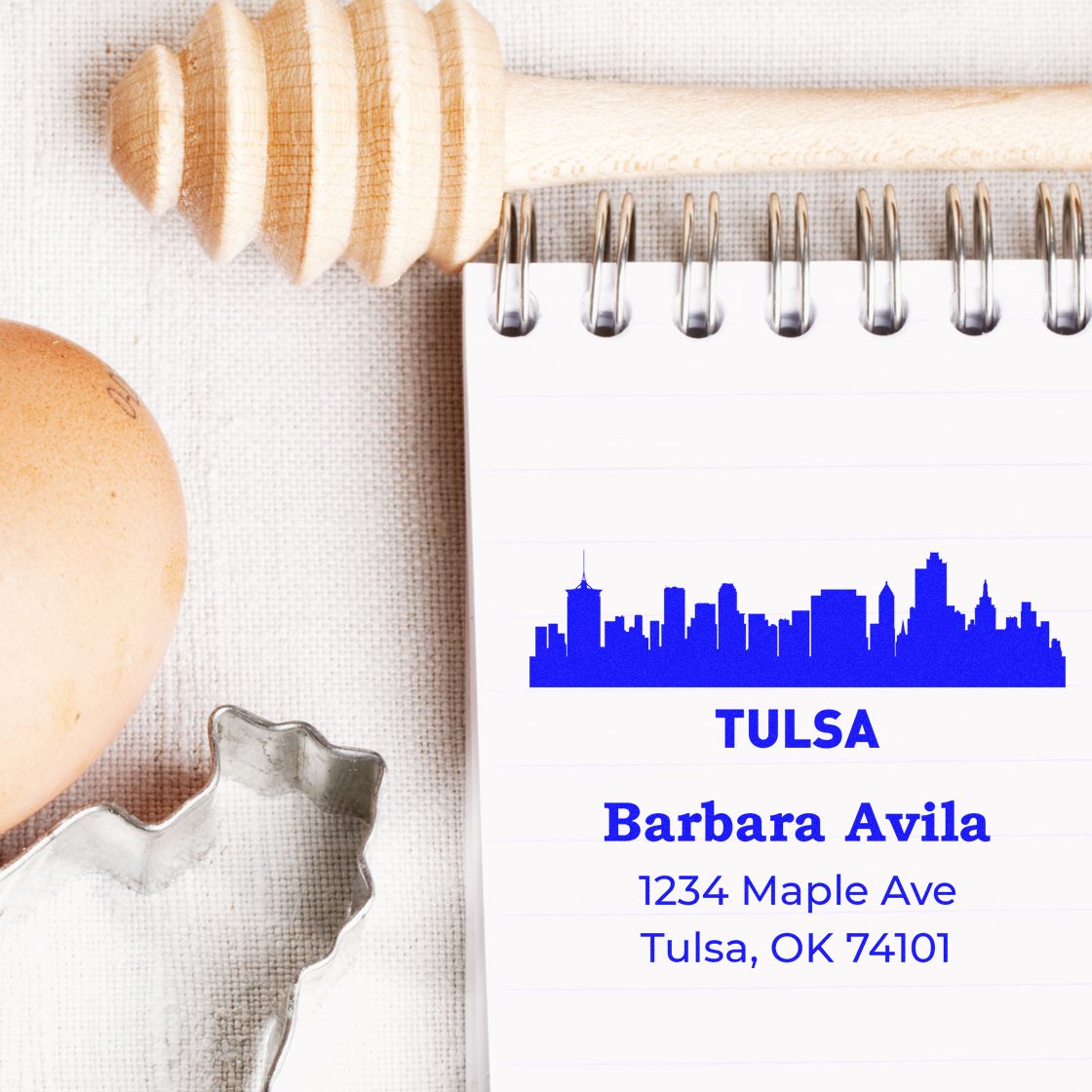 Custom Tulsa address rubber stamp with skyline design for Barbara Avila, 1234 Maple Ave, Tulsa, OK 74101 on a notepad.