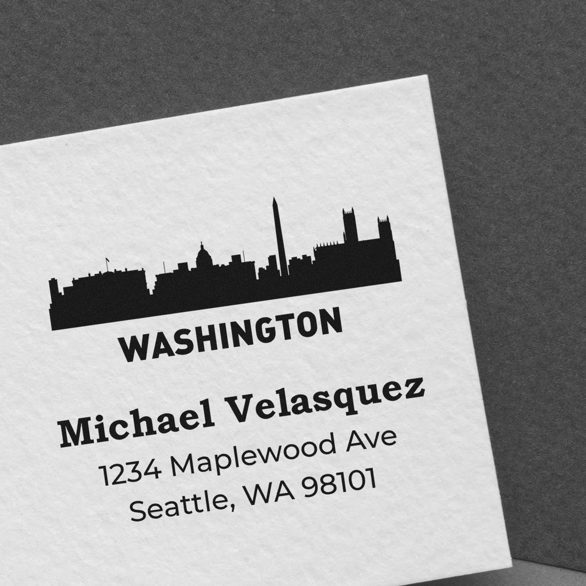 Custom Washington skyline address rubber stamp with personalized name and Seattle, WA mailing details on paper.
