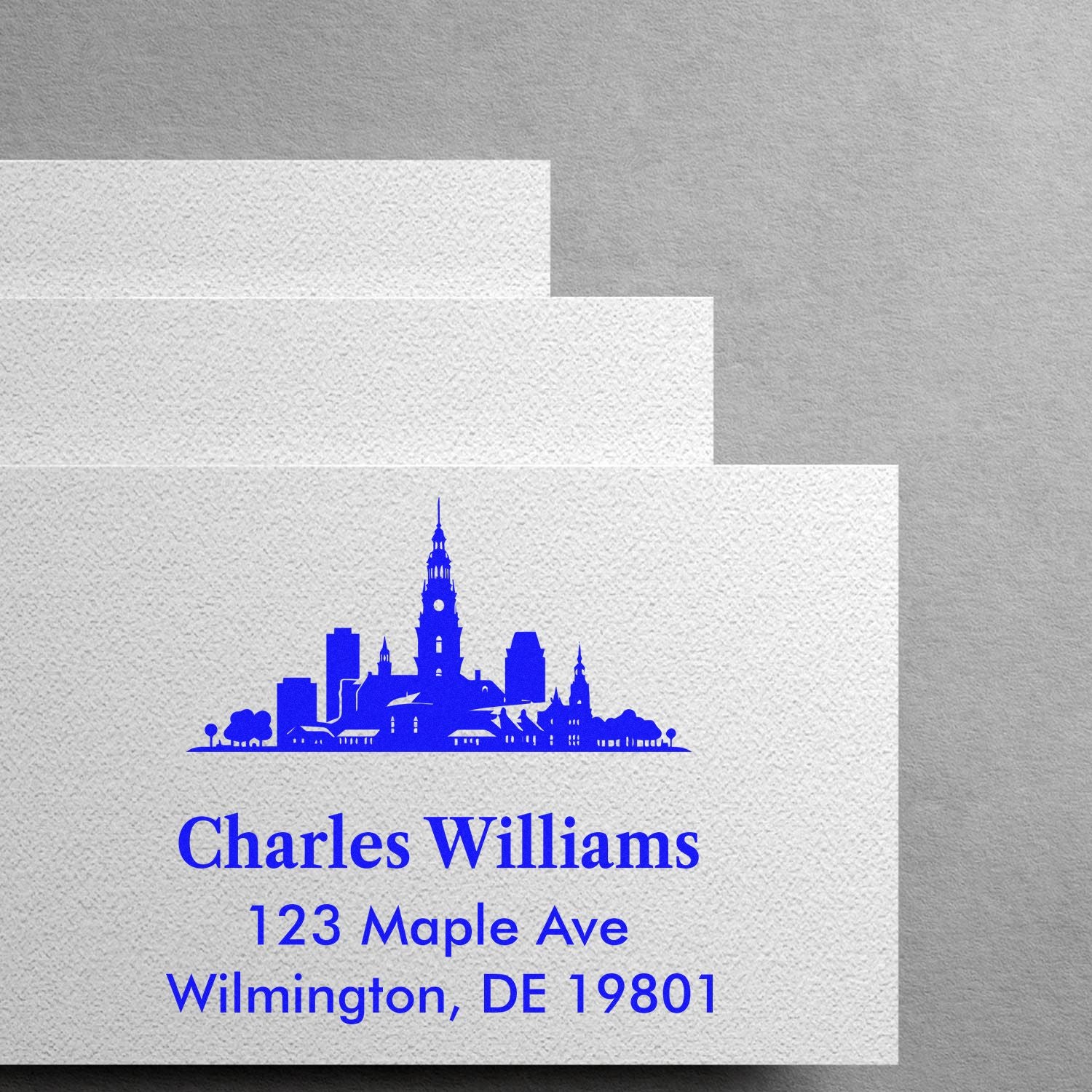 Custom address rubber stamp with city skyline design for Charles Williams, 123 Maple Ave, Wilmington, DE 19801.