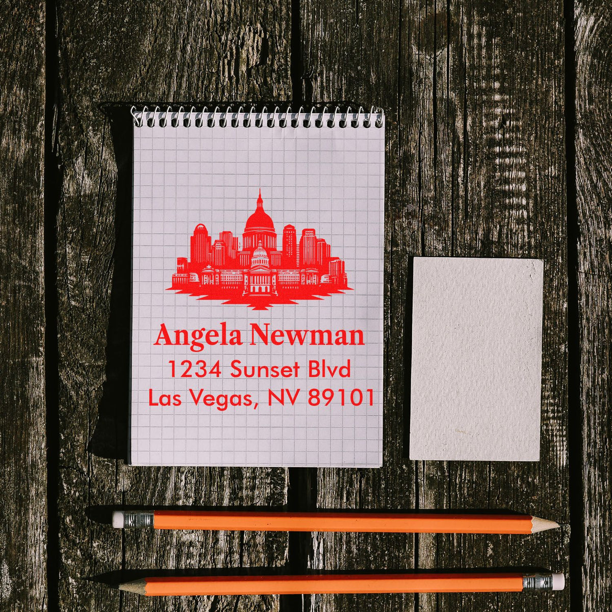 Red custom address rubber stamp imprint with Las Vegas skyline, personalized name and address on notebook.