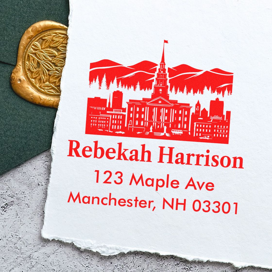 Custom address rubber stamp with red city skyline design for Rebekah Harrison, 123 Maple Ave, Manchester, NH 03301.
