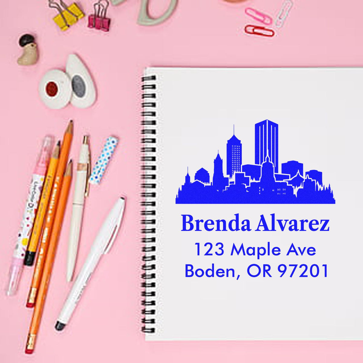 Custom return address rubber stamp with skyline design, personalized for Brenda Alvarez on a spiral notebook.