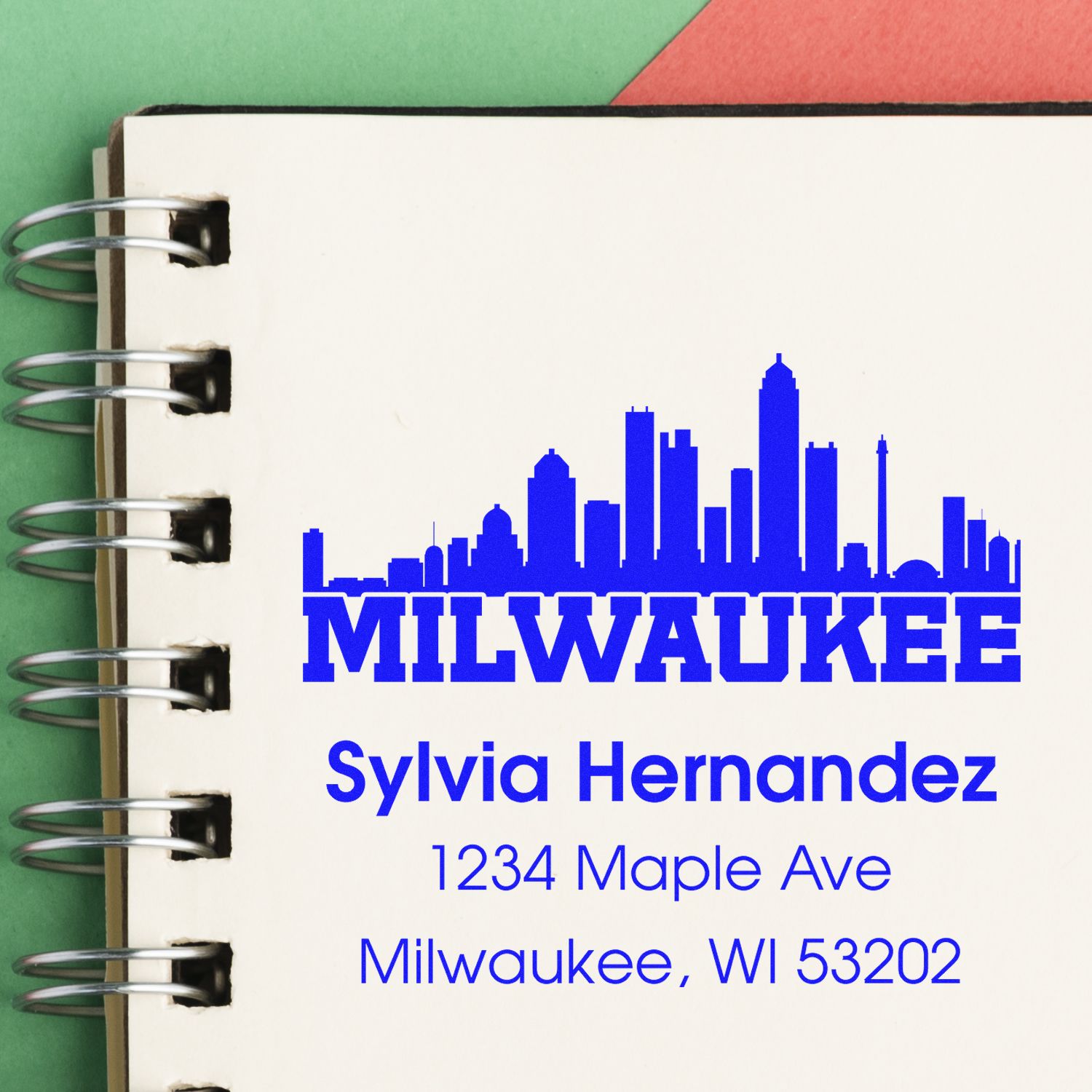 Custom Milwaukee skyline address stamp with Sylvia Hernandez name and 1234 Maple Ave, WI 53202, on notebook page.