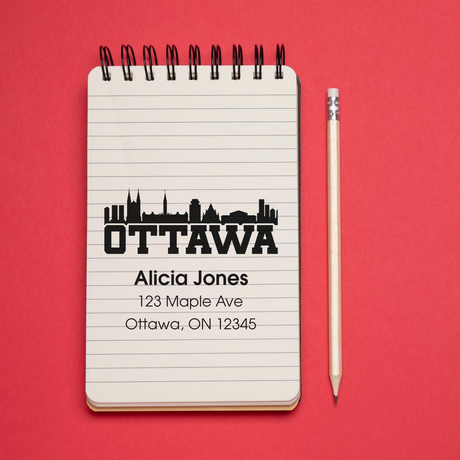 Custom Ottawa address rubber stamp with skyline design and personalized return address on a notebook.