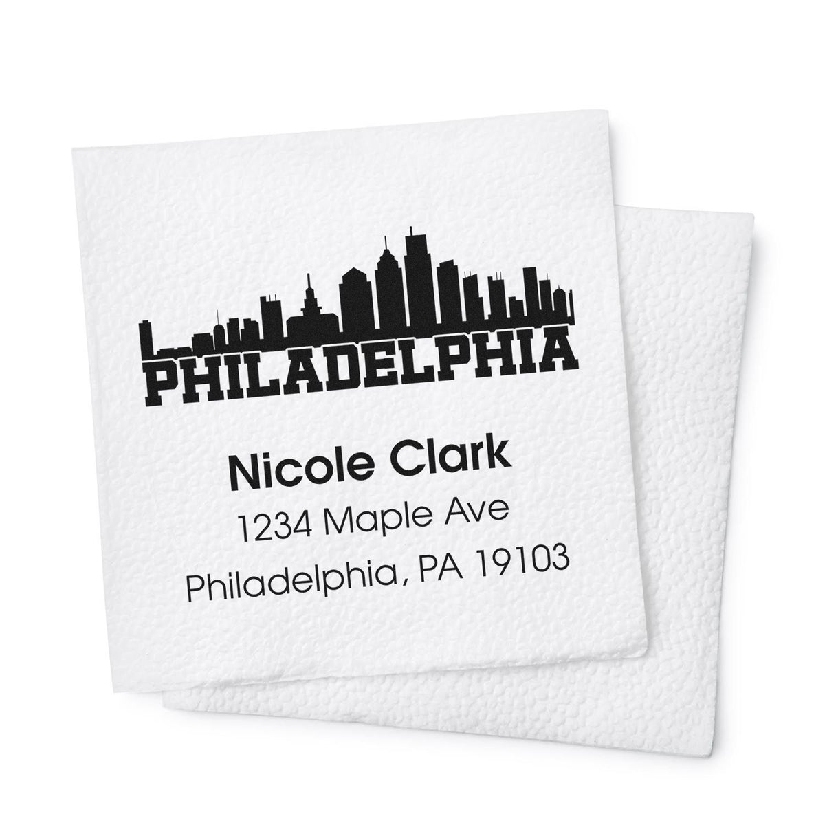 Custom Philadelphia skyline address rubber stamp with Nicole Clark return address and 1234 Maple Ave on white paper.