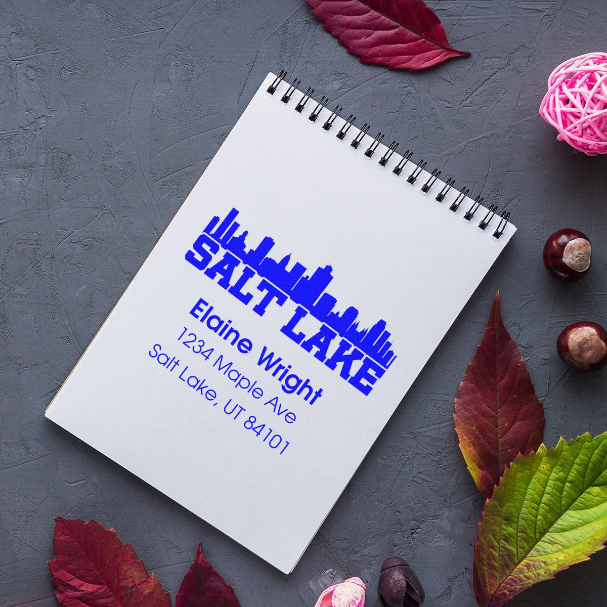 Custom Salt Lake City address rubber stamp on notebook, featuring skyline design and personalized name, street, and ZIP code.