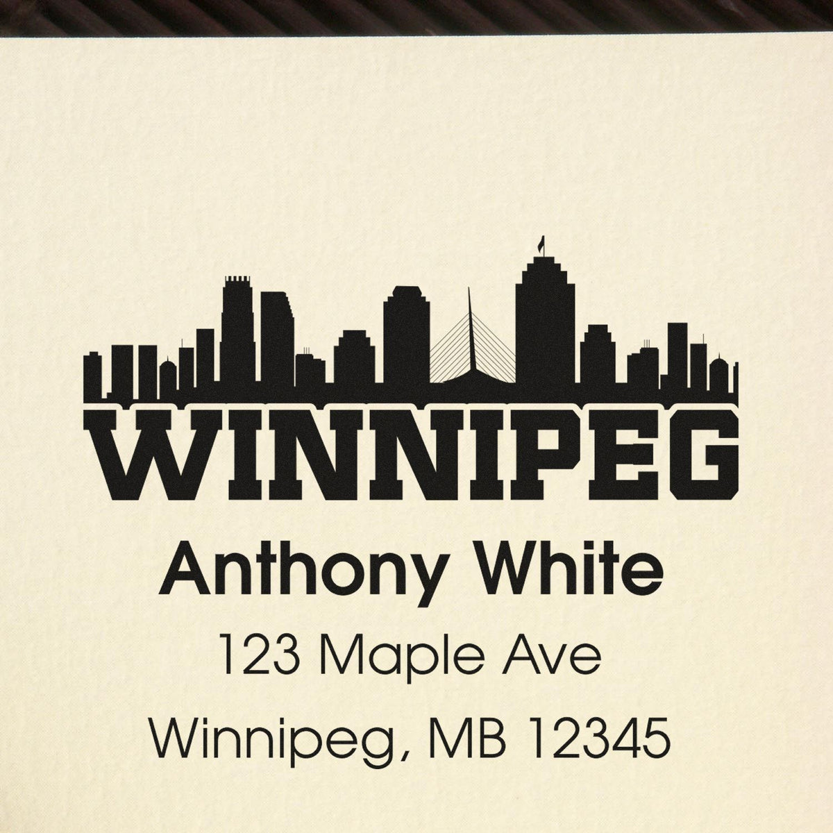 Custom return address rubber stamp with Winnipeg skyline for Anthony White, 123 Maple Ave, Winnipeg, MB 12345.