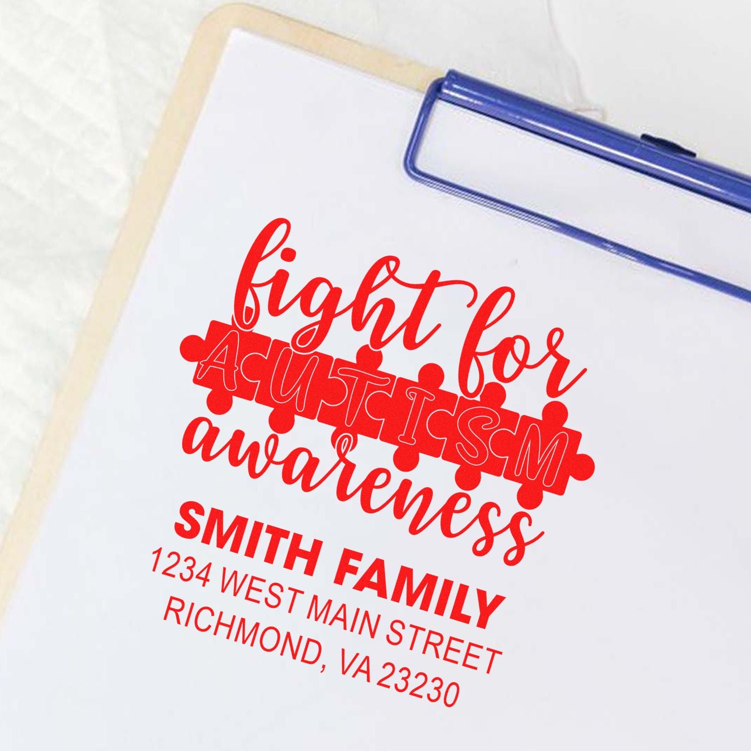 Custom rubber stamp for Autism Awareness with Smith family name and address in red ink.