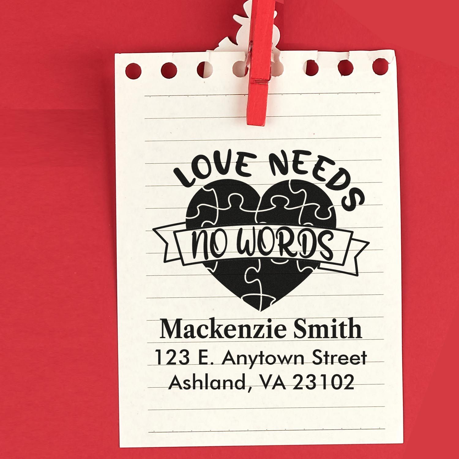 Custom rubber stamp design with Love Needs No Words heart puzzle and personalized return address on lined paper.