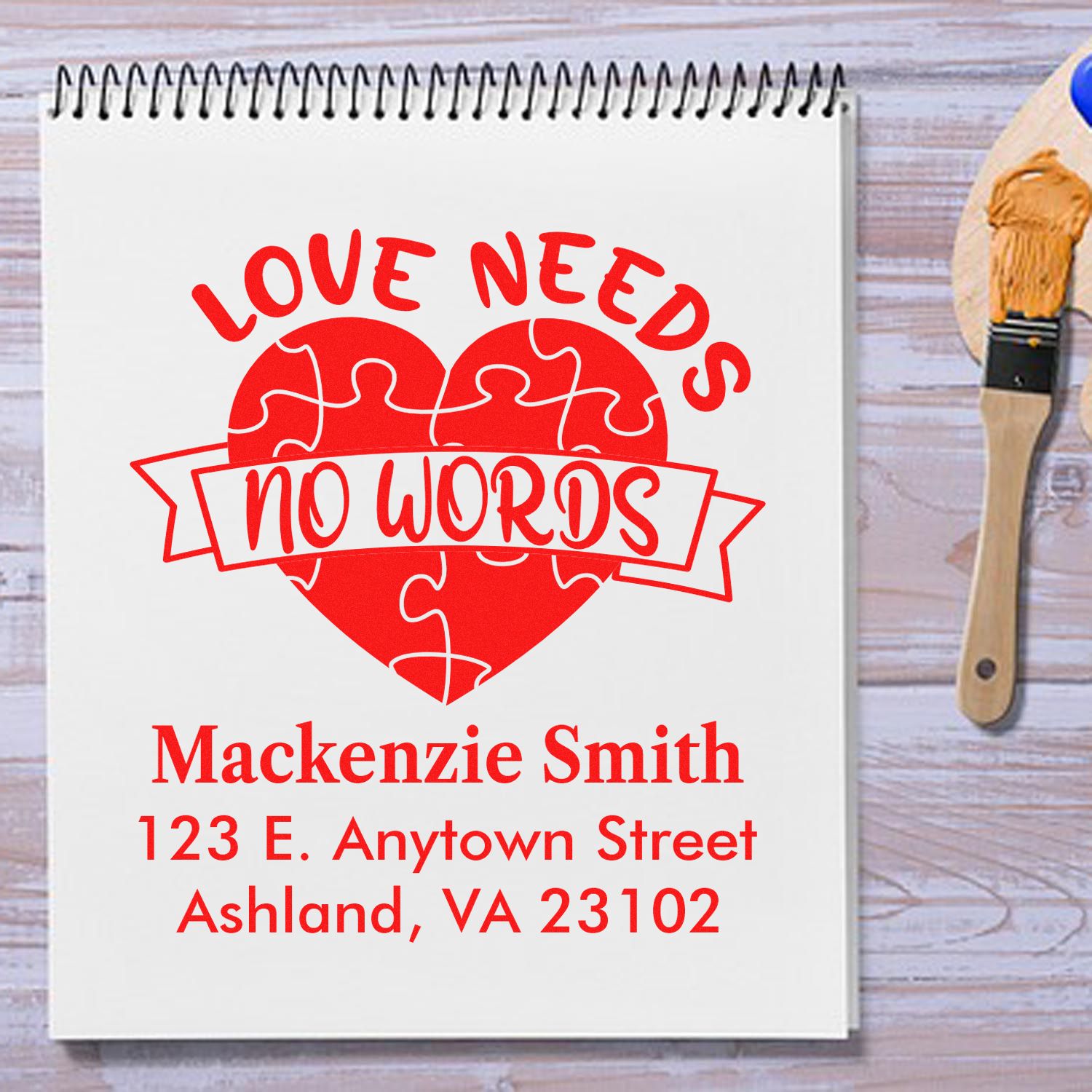 Custom rubber stamp design with heart puzzle art, Love Needs No Words, and personalized return address for gift or stationery.
